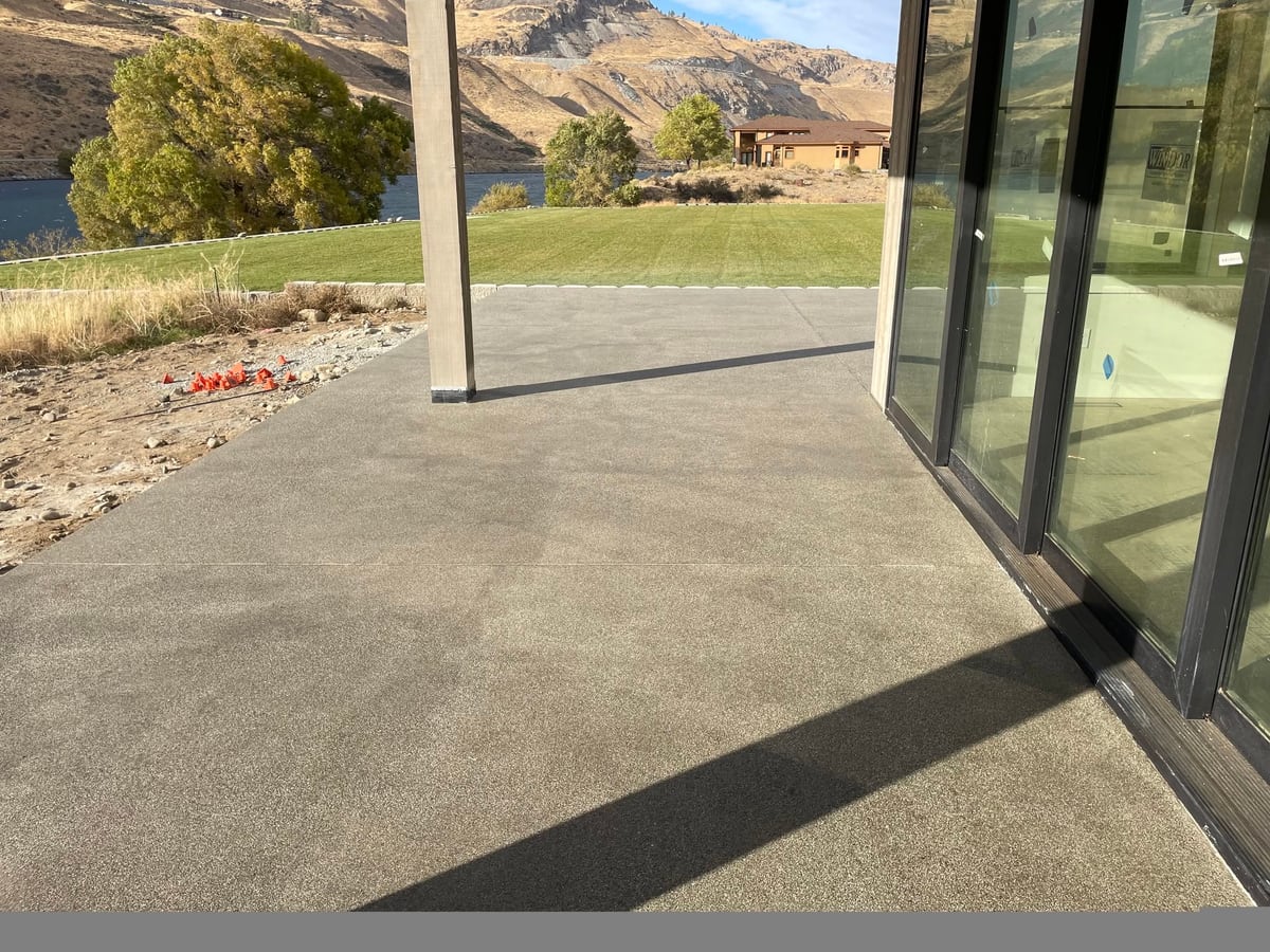 Covered patio slab at the lakeside house with a river and cliffs beyond.