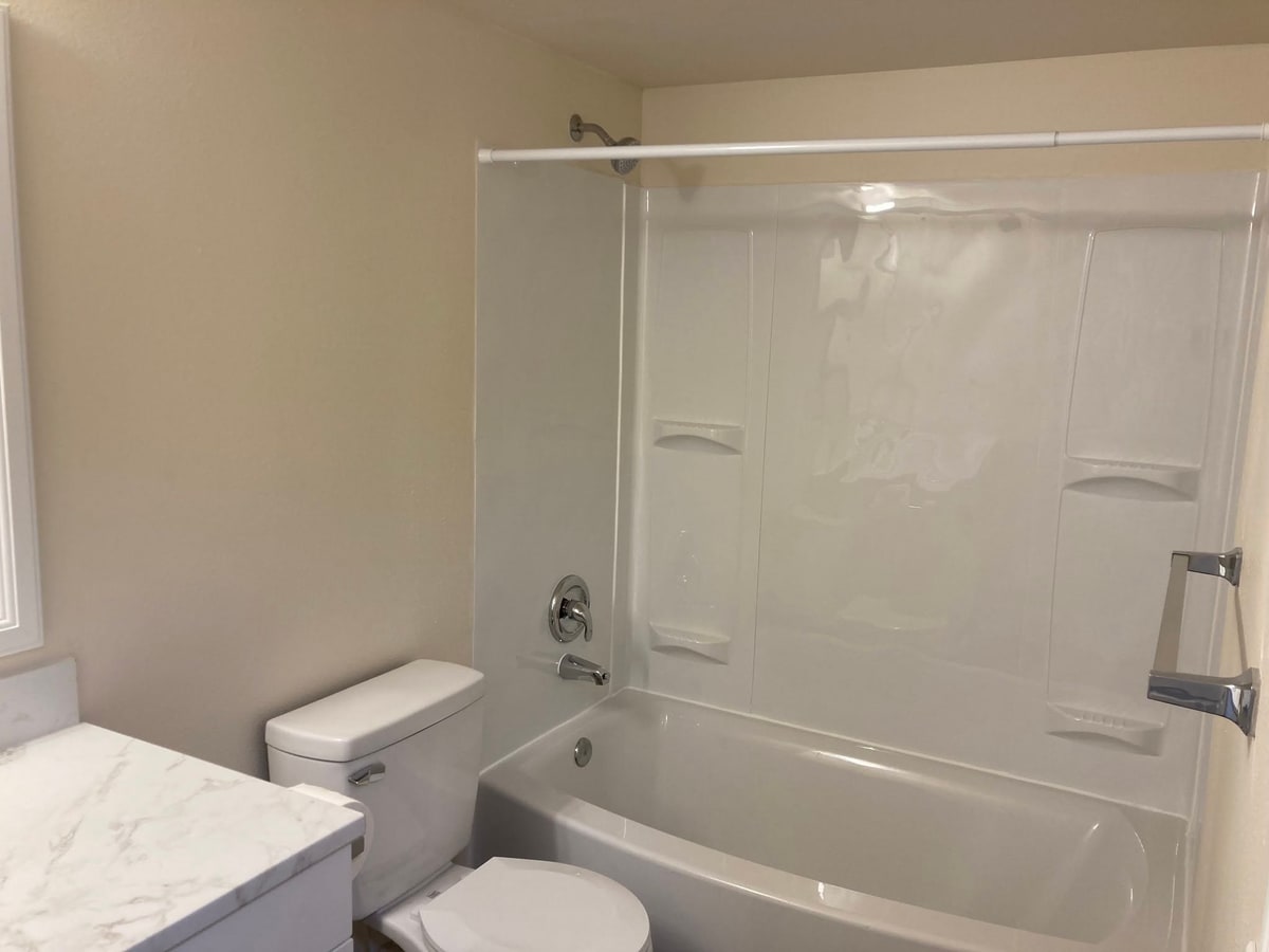 New tub and surround with shower fixture.