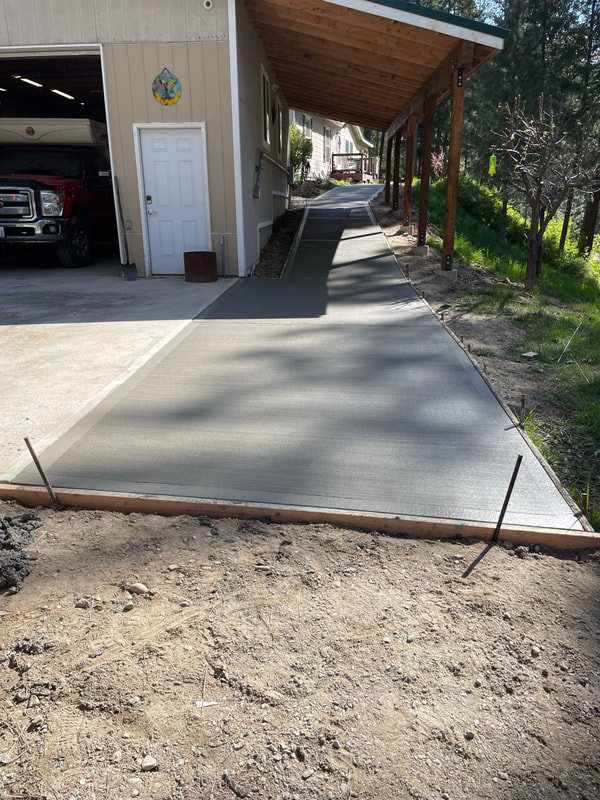 New driveway slab to the garage under a covered lean-to.