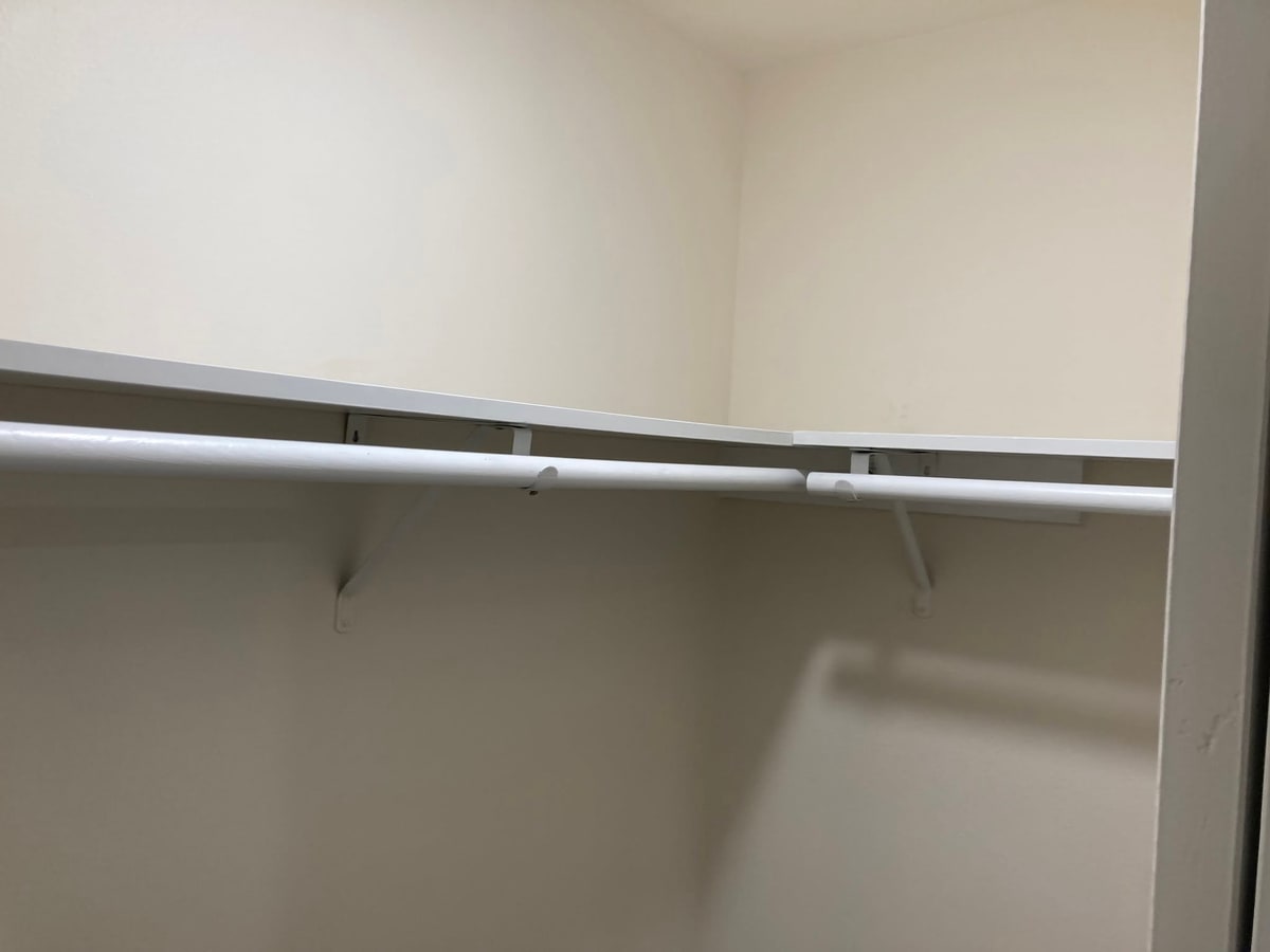 New closet shelf and rod in a freshly painted closet.