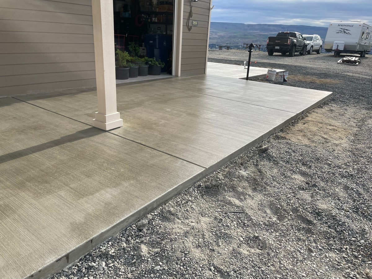 Covered patio slab with a view to parked trucks and a trailer.