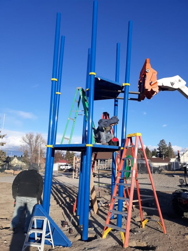 Worker on the tower platform with a crane arm above.