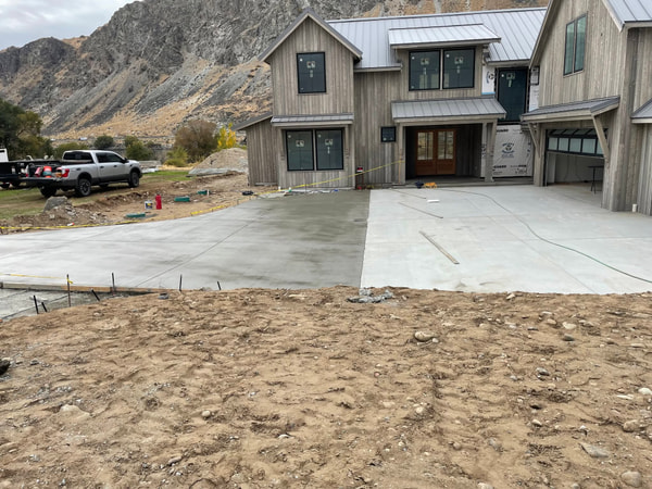 Front driveway of the modern house with trucks and mountains.
